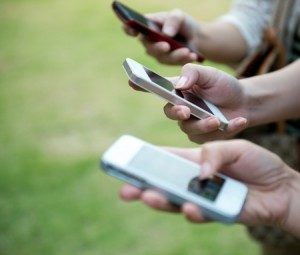 Three people using their phones