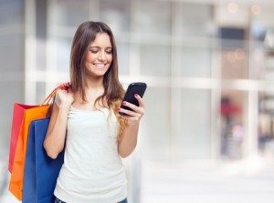 Woman on her phone holding shopping bags